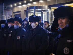 Chinese security guards, most wearing protective masks, line up before duty on February 9, 2020 in Beijing, China. The number of cases of a deadly new coronavirus rose to more than 37000 in mainland China Sunday, days after the World Health Organization (WHO) declared the outbreak a global public health emergency.