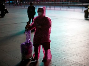 A woman wears a face mask and plastic raincoat as a protection from coronavirus at Shanghai railway station, in Shanghai, China February 17, 2020.