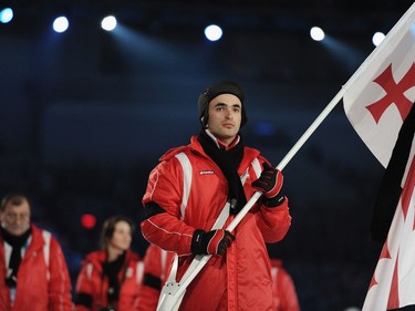 VANCOUVER, BC - FEBRUARY 12:  Iason Abramashvili of Georgia carries his national flag into the stadium during the Opening Ceremony of the 2010 Vancouver Winter Olympics at BC Place on February 12, 2010 in Vancouver, Canada. The Georgian flag carries a black band in memory of Georgian luger Nodar Kumaritashvili, who was killed today after crashing while making a practice run in training.