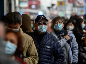 People queue to buy face masks from a shop in Hong Kong on Feb. 1 as a preventive measure after a virus outbreak that began in the Chinese city of Wuhan.