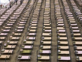 Workers set up beds at an exhibition centre that was converted into a hospital in Wuhan in China's central Hubei province on February 4, 2020. -