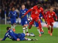 Bayern Munich's Canadian midfielder Alphonso Davies (C) hurdles the challenge from Chelsea's Danish defender Andreas Christensen (L) on his way to setting up their third goal during the UEFA Champion's League round of 16 first leg football match between Chelsea and Bayern Munich at Stamford Bridge in London on February 25, 2020.