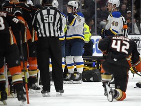 Teammates look on as St. Louis Blues defenseman Jay Bouwmeester, who suffered a medical emergency, is worked on by medical personnel during the first period of an NHL game on Feb. 11.