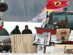 Protesters stand near blockaded train tracks in Tyendinaga Mohawk Territory near Belleville, Ont. on Feb. 18, 2020.