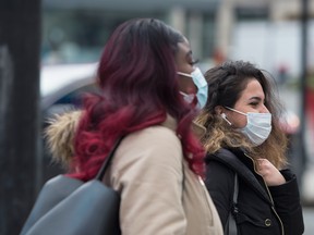 Pedestrians wear masks in downtown Toronto as more positive coronavirus patients have been confirmed.