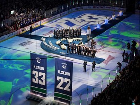 Henrik and Daniel Sedin and their families watch the jersey retirement Wednesday.