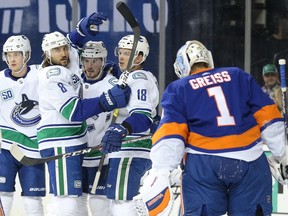 The Vancouver Canucks celebrate after scoring on New York Islanders goalie Thomas Greiss during Saturday's NHL game at the Barclays Center. Vancouver won 4-3 in overtime.