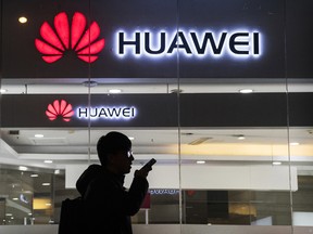 A pedestrian walks past a Huawei store in Beijing, China.