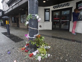 Flowers are laid in front of the Cabana Lounge nightclub on Granville Street where four people were stabbed early Saturday morning.