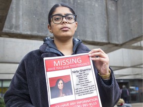 Vanessa Sharma holds a poster for her mother, Nirla Sharma, who disappeared on Monday.