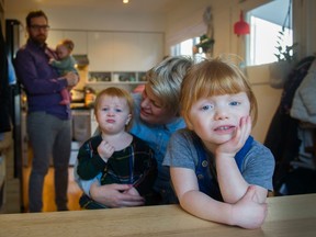 Mother Caryn Matheson, centre, with Mae, 2, father Dan, left, with Lucy, five months, and Annie, 5, foreground, at their home in Vancouver on Sunday.