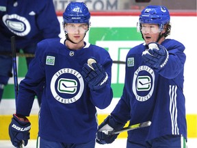 New Canuck Tyler Toffoli, right, discusses a few things with Elias Pettersson during the NHL team's Tuesday practice at Rogers Arena in Vancouver.