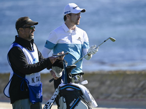 February 7, 2020; Pebble Beach, California, USA; Nick Taylor (right) and his caddie on the 18th hole during the second round of the AT&T Pebble Beach Pro-Am golf tournament at Pebble Beach Golf Links.