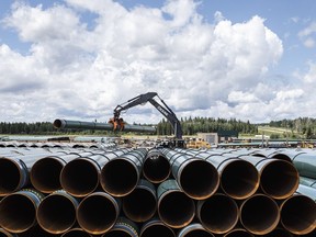 In this June 18, 2019 file photo, pipe for the Trans Mountain pipeline is unloaded in Edson, Alta.