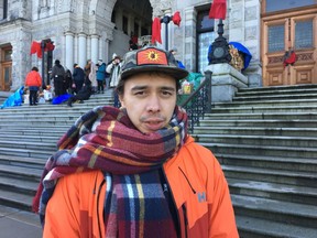 Protester Kolin Sutherland-Wilson is shown at the legislature in Victoria, Saturday, Feb.8, 2020. Protesters supporting the Wet'suwet'en hereditary chiefs fight against the Coastal GasLink pipeline in northern B.C. spent the night camped outside the legislature. Their camp includes a ceremonial fire on the front steps.