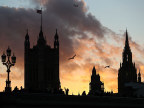 A plane descends into Heathrow as the sun sets behind the Palace of Westminster in central London, on December 7, 2018. (DANIEL LEAL-OLIVAS/AFP/Getty Images)