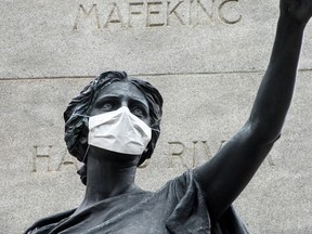 A surgical mask placed on a remembrance statue in Toronto for those who died serving in the South African War 1899-1902, as concerns of the Covid 19 virus continue, Thursday March 19, 2020.