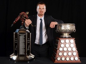 Daniel Sedin of the Vancouver Canucks poses with the Ted Lindsay Award (most outstanding player voted on by the players, on the left) and the Art Ross Trophy as the league's leading scorer at the 2010-11 NHL Awards in Las Vegas on June 22, 2011.