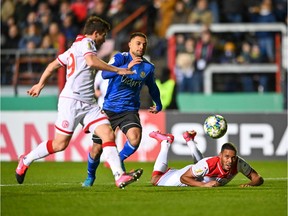 Saarbrücken's Kianz Froese, middle, wins the ball against Düsseldorf's Markus Suttner, left, and Zanka during their DFB Pokal quarter-final game at Hermann Neuberger Stadium on March 3. Froese, a former Vancouver Whitecap, assisted on Saarbrücken's only goal in regulation.