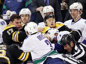 Boston Bruins winger Milan Lucic (left) and Canucks defenceman Kevin Bieksa tangle near the Canucks bench during a testy 4-3 Canucks win on Jan. 7, 2012 in Boston. It was the first game the two teams faced each other since the Bruins' Stanley Cup Final series win over Vancouver the previous spring.