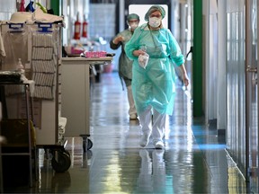 Medical workers wearing protective masks and suits walk in an intensive care unit at the Oglio Po hospital, where patients suffering from coronavirus disease (COVID-19) are treated, in Cremona, Italy March 19, 2020.