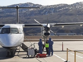 Cleaners can be seen preparing to board Air Canada flight AC8425 in Kamloops, B.C. on March 8, 2020, after a passenger reported falling ill during the flight.