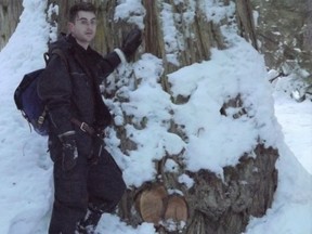 Sean O'Rourke stands next to one of the Western redcedar trees in Ancient Forest-Chun T'oh Wudujut Provincial Park from which a burl has been removed.