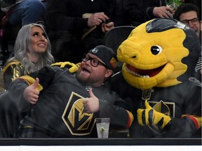 The Vegas Golden Knights' mascot, Chance the Golden Gila Monster, poses with a fan during a recent NHL game at T-Mobile Arena in Las Vegas.