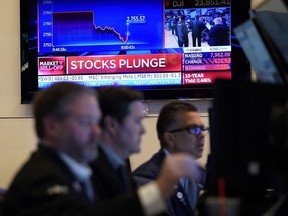 Traders work on the floor during the opening bell on the New York Stock Exchange on Monday, March 9, 2020 in New York. Trading on Wall Street was temporarily halted early Monday as U.S. stocks joined a global rout on crashing oil prices and mounting worries over the coronavirus.