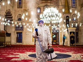 A member of the Istanbul's Municipality disinfects the Kilic Ali Pasa Mosque to prevent the spread of the COVID-19 in Istanbul, on March 11, 2020. -