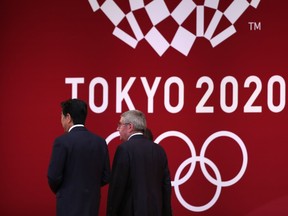 In this file photo taken on July 24, 2019 International Olympic Committee president Thomas Bach (R) walks with Japan's Prime Minister Shinzo Abe (L) as they leave the stage during a ceremony marking one year before the start of the Tokyo 2020 Olympic Games in Tokyo.