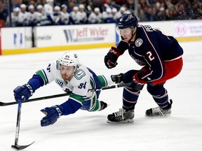 Vancouver Canucks center Brandon Sutter (20) reaches for the puck ahead of Columbus Blue Jackets defenseman Markus Nutivaara (65) in the first period at Nationwide Arena.