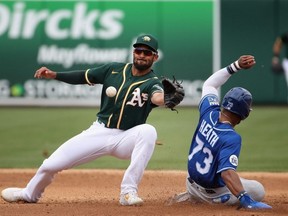 Marcus Semien of the Athletics, left, catches the ball as Royals baserunner Nick Heath steals second base during second inning MLB spring training action at HoHoKam Stadium in Mesa, Ariz., on March 10, 2020.