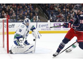 Vancouver Canucks' Louis Domingue, left, makes a save against Columbus Blue Jackets' Pierre-Luc Dubois during the second period of an NHL hockey game Sunday, March 1, 2020, in Columbus, Ohio.