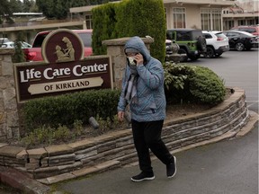 A woman walks out of the Life Care Center of Kirkland as an ambulance transports a patient from the long-term care facility, which is linked to the two of three confirmed coronavirus cases in the state, in Kirkland, Washington, U.S. March 1, 2020. REUTERS/David Ryder