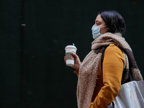 A woman wears a mask on Wall St. near the New York Stock Exchange on Monday.