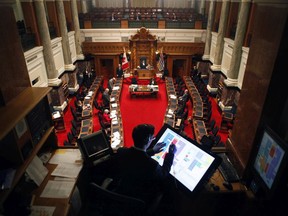 John Horgan and a dozen MLAs gather in the legislative assembly to make special statements about the COVID-19 pandemic during a rare event at the Legislature in Victoria, B.C., on Monday, March 23, 2020.