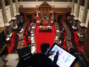 Premier John Horgan and a dozen MLAs gather in the legislative assembly to make special statements about the COVID-19 pandemic during a rare event at the legislature in Victoria.