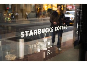 The front window of a downtown Starbucks Coffee store is shown in Toronto, May 10, 2018. Starbucks is stopping the use of reuseable cups and is halting business travel to combat the spread of the novel coronavirus.