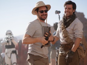 Director J.J. Abrams and star Oscar Isaac on the set of Star Wars: The Rise of Skywalker, while a stormtrooper looks scarily in character behind them.