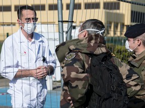 French soldiers talk with the head of SAMU 68, Marc Noizet, during the construction of the military field hospital in Mulhouse on March 22, 2020. (SEBASTIEN BOZON/AFP via Getty Images)