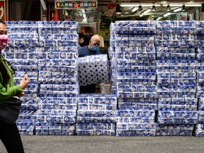 A woman walks past stacks of toilet paper for sale in the Tsuen Wan district of Hong Kong on February 8, 2020.