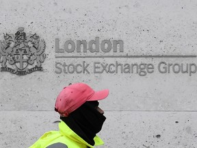 A man walks past the London Stock Exchange Group building in the City of London financial district.