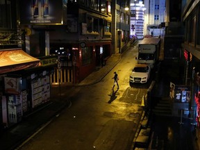 A woman walks past an almost empty pub area, following the novel coronavirus disease (COVID-19) outbreak, at Lan Kwai Fong, a popular nightlife destination in Central, Hong Kong, China March 20, 2020.