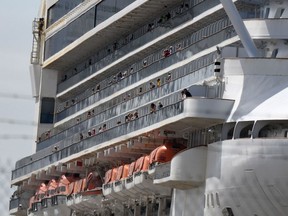 People watch embarkation preparations being made aboard the Grand Princess cruise ship carrying passengers who have tested positive for coronavirus docked at the Port of Oakland in Oakland, California.