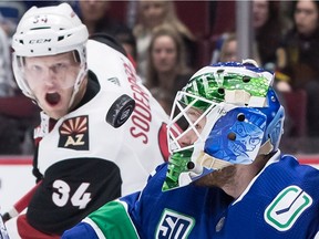 Vancouver Canucks goalie Thatcher Demko, right, makes a save as Arizona Coyotes' Carl Soderberg watches during the first period.