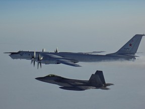 An American F-22 escorts a Russian Tu-142 Bear aircraft in international airspace near Alaska in this March 2020 handout photo. Military authorities say U.S. and Canadian fighter jets were scrambled Monday to intercept two Russian reconnaissance planes travelling near the North American coastline. The North American Aerospace Defence Command says the two Russian Tu-142 Bear aircraft flew within 92 kilometres remained in international airspace north of Alaska for about four hours before departing.
