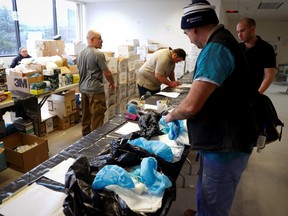 Will Swanson, a Registered Nurse (RN) from Columbia University picks up personal protective equipment (PPE) and other supplies for use by medical field personnel at a New York State emergency operations incident command center during the coronavirus outbreak in New Rochelle, New York, U.S., March 17, 2020.