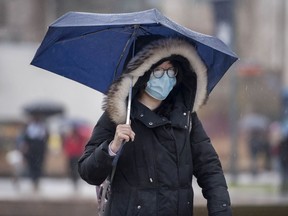 A UBC student doesn't let eyeglasses get in the way of donning a surgical mask during a walk on campus on Monday.
