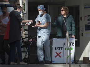 While B.C. continues to battle the COVID-19 pandemic, officials have ordered a number of non-essential businesses to close if they cannot ensure safe physical distance. Visitors to St. Paul's Hospital in Vancouver, B.C. are pictured being screened before they enter the hospital Friday, March 20, 2020.